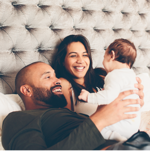 Couple in bed looking at a newborn